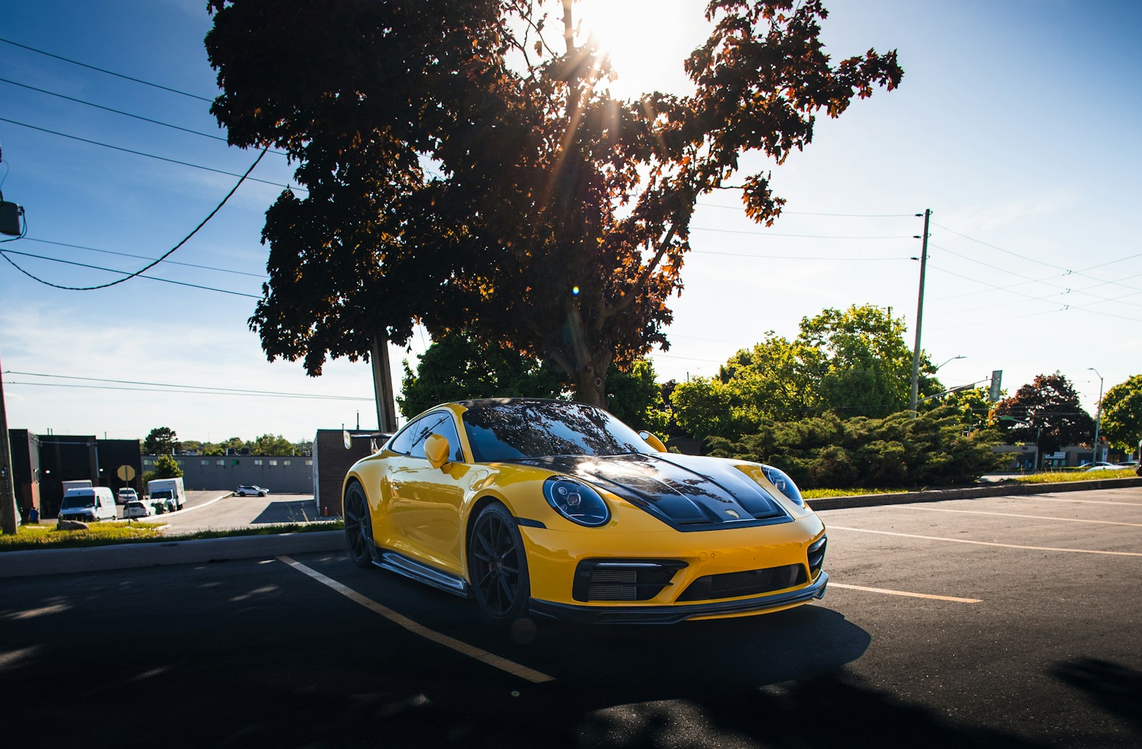 A yellow sports car driving down a street